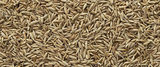 Close-up of whole cumin seeds showing their distinctive brown, elongated boat shape