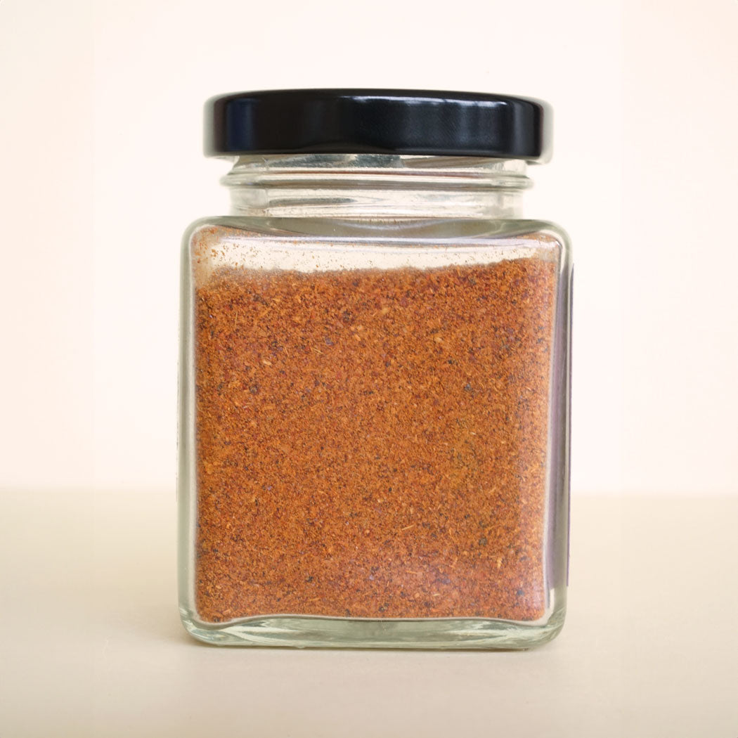 Close-up of a back of jar filled with biryani masala spice mix, featuring a colourful blend of aromatic Indian spices.