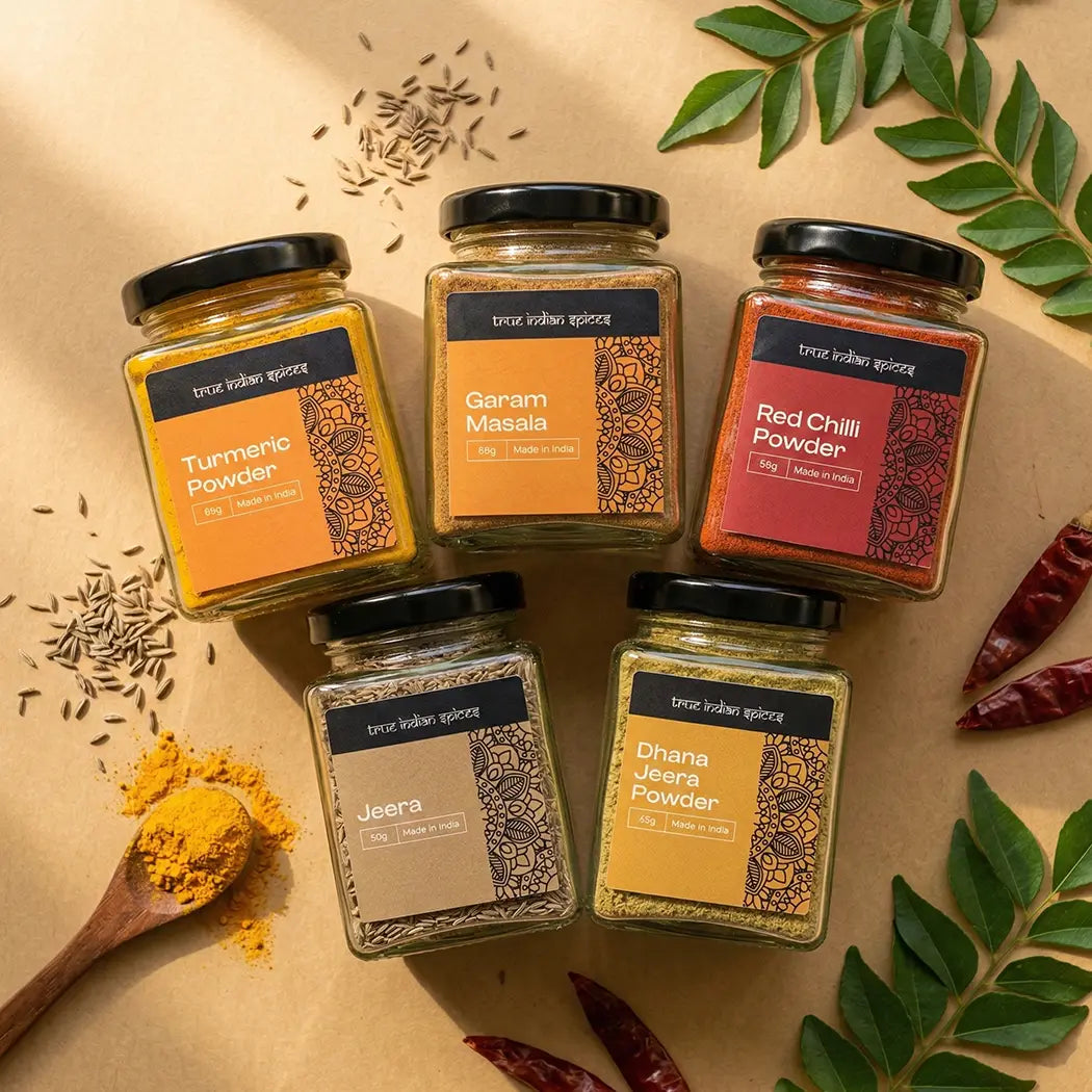 Five jars of spices on a beige background with herbs and spices around